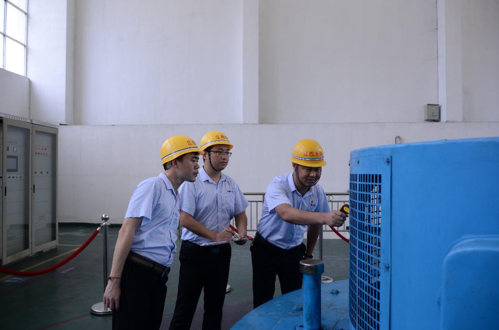 吴健与同事对发电机组设备进行温度检测（左二）